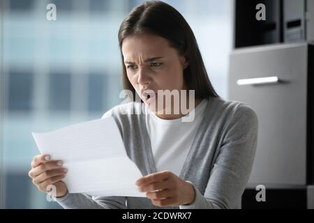 Wütend verärgert junge Geschäftsfrau lesen Brief, erhielt schlechte Nachrichten Stockfoto