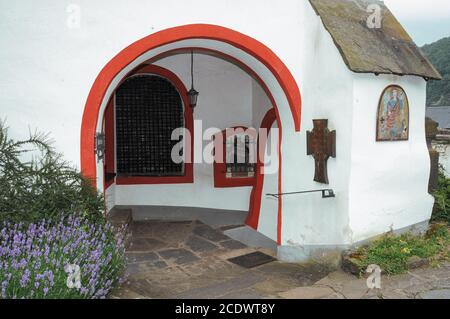 Die Bögen unter der alten Michaelskirche an der Mosel in Alken, Rheinland-Pfalz, bieten einen Blick durch die alten Eisengitter der Schädel und Knochen mittelalterlicher Gemeindemitglieder, die in ihrem Gebeinhaus (Leichenhaus, Knochenhaus oder Beinhaus) aufgetürmt sind. Die im frühen 15. Jahrhundert für neue Einlagen gesperrt wurde. Die alte St. Michaelskirche, 1015 erwähnt, ist eine der ältesten Kirchen im Mosel- oder Moselgebiet. Im Inneren befinden sich Fresken aus dem 13. Jahrhundert. Stockfoto