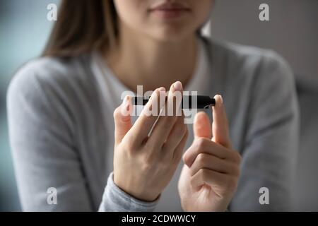 Nahaufnahme junge Frau mit Lanzette Stift, Messung des Glukosespiegels Stockfoto