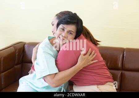 Die kranke asiatische Mutter im Krankenhaus umarmte ihre Tochter vor Freude. Stockfoto