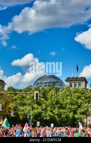 Berlin, Deutschland, 29. August 2020: Weiß-blauer Himmel über der Kuppel des Berliner Reichstags und eine Demonstration gegen die Corona-Beschränkungen Stockfoto