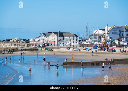 Lyme Regis, Dorset, Großbritannien. August 2020. UK Wetter: Hardy Urlauber und Familien setzen sich am Strand an einem hellen, aber kühlen August-Feiertag Sonntag auf. Die Besucher sind entschlossen, das Beste aus den sonnigen, wenn auch eher kalten Bedingungen am letzten Wochenende der Schulferien zu machen. Kredit: Celia McMahon/Alamy Live Nachrichten Stockfoto