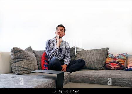 Mann auf der Couch erwägt Optionen Stockfoto