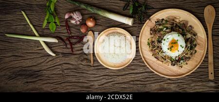 Gebratenes Fleisch mit Bambushoot und heiligem Basilikum serviert mit Gedünstetes Reis Spiegelei Stockfoto