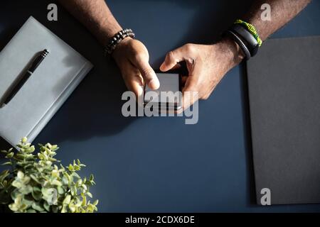 Afroamerikanischer Geschäftsmann, der am Schreibtisch sitzt und telefoniert Stockfoto