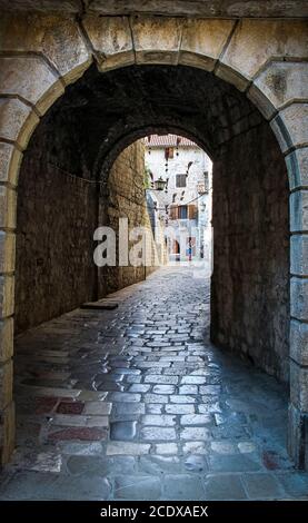 Eine Gasse in der Altstadt von Kotor, mit fliegenden Besen im Hintergrund, Montenegro Stockfoto