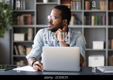 Verträumt nachdenklichen afroamerikanischen Geschäftsmann Blick zur Seite Stockfoto