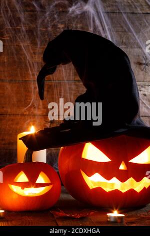 Jack O Lantern Halloween Kürbis mit Hexen Hut, Spinnen auf Web- und brennende Kerzen Stockfoto