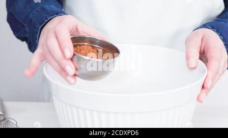 Schritt für Schritt. Das Mischen von Zutaten zusammen in einer weißen Schüssel unicorn chocolate Cupcakes mit buttercream Frosting zu machen. Stockfoto