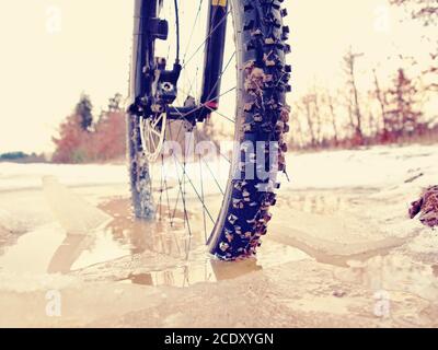 Extrem niedrige Knöchel Ansicht schließen zu Mountainbike im Schnee eisiger Spur blockiert. Extreme weiten Blick Stockfoto