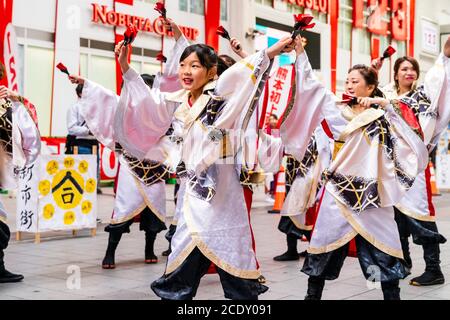 Japanisches Team von yosakoi-Tänzern in langärmeligen Yukata-Tänzen in Einkaufspassagen während des Kyusyu Gassai Festivals in Kumamoto in Japan. Stockfoto