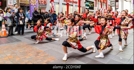 Japanisches Team von yosakoi-Kindertänzern mit Naruko, Holzklatschern und Tanz in der Einkaufspassage Sun Road während des Kyusyu Gassai Festivals. Stockfoto