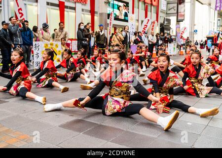 Japanisches Team von yosakoi-Kindertänzern mit Naruko, Holzklatschern und Tanz in der Einkaufspassage Sun Road während des Kyusyu Gassai Festivals. Stockfoto