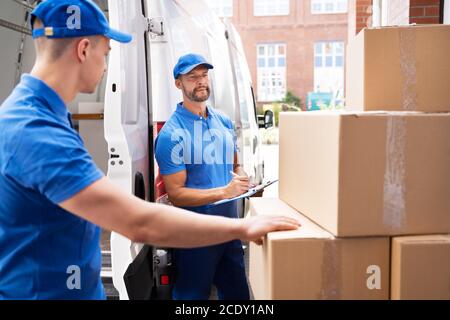 Van Courier Und Professional Movers Unload Truck Stockfoto