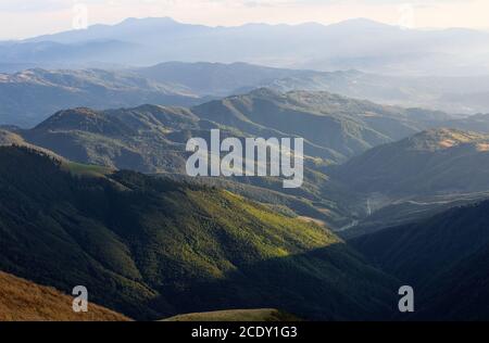 Berglandschaft mit schönem Sonnenuntergang, bewölktem Himmel und orangefarbenem Horizont. Fantastische ländliche Herbstlandschaft. Stockfoto