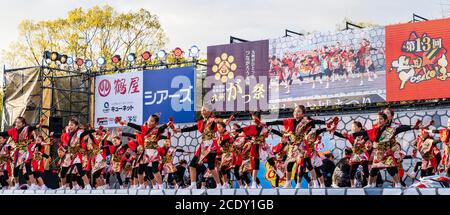 Team japanischer yosakoi-Kindertänzer auf der Bühne beim Tanz mit Naruko, Holzklatschern, während des Kumamoto Kyusyu Gassai Tanzfestivals in Japan Stockfoto