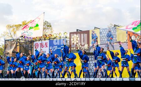 Japanisches yosakoi-Kinderteam, Mädchen-Tänzerinnen auf der Bühne mit Naruko, Holzklatschern, beim Tanzen auf dem Kyusyu Gassai-Festival, Kumamoto in Japan Stockfoto