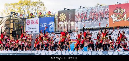 Team japanischer yosakoi-Kindertänzer auf der Bühne beim Tanz mit Naruko, Holzklatschern, während des Kumamoto Kyusyu Gassai Tanzfestivals in Japan Stockfoto