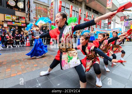 Team von japanischen yosakoi-Tänzern in Einkaufspassagen, die beim Kumamoto Kyusyu Gassai Festival in Japan Naruko, Holzklatschklatschklatschklatschchen, tanzen Stockfoto