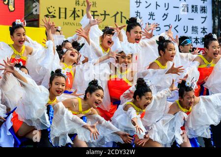 Japanisches Team von Kindern yosakoi Mädchen Tänzerinnen, 10-11 Jahre alt, auf der Bühne im Freien tanzen im Kyusyu Gassai Tanzfestival in Kumamoto, Japan. Stockfoto