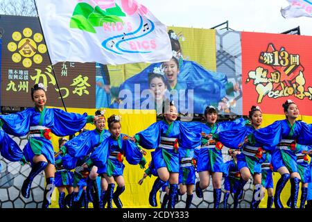 Japanisches yosakoi-Kinderteam, Mädchen-Tänzerinnen auf der Bühne mit Naruko, Holzklatschern, beim Tanzen auf dem Kyusyu Gassai-Festival, Kumamoto in Japan Stockfoto