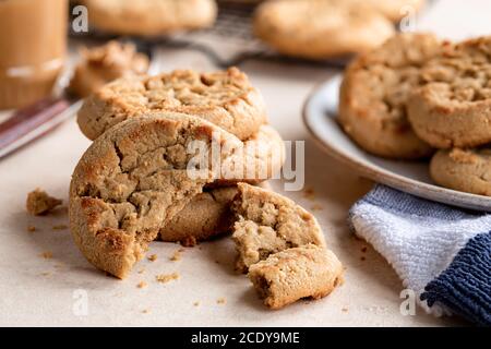 Erdnussbutterkekse, Nahaufnahme des Stapels und zerbrochene Stücke auf dem Tisch Stockfoto