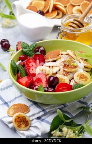 Porridge von winzigen Pfannkuchen mit Beeren. Trendiges Essen. Stockfoto
