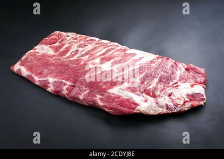 Roh Kalbfleisch Ersatz Lendenrippen St Louis geschnitten angeboten als Nahaufnahme auf schwarzem Hintergrund Stockfoto