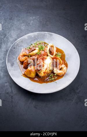 Traditioneller brasilianischer Fischeintopf Moqueca capixaba mit Fischfilet und King Garnelen in Tomatensauce als Nahaufnahme auf einem modernen Ausführung p Stockfoto