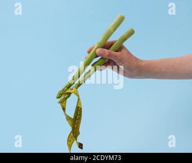 Spargelspieße in der Hand einer Frau mit gelbem Maßband. Stockfoto