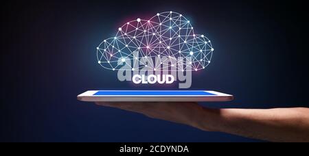 Cloud-Datenspeichertechnologie. Man Holding Digital Tablet Mit Polygonal Cloud Hologramm Stockfoto