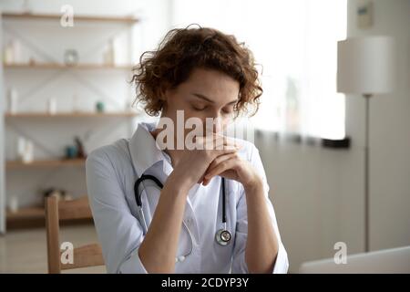 Nahaufnahme nachdenkliche Frau Arzt sitzt am Schreibtisch Stockfoto