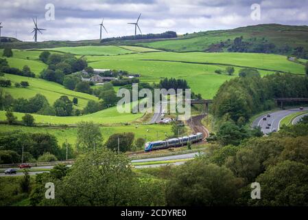 Eine Trans PennineClass 397 Civity auf den Kurven auf der West Coast Hauptlinie am Beck Foot bei Tebay gesehen, mit der M6 läuft neben. Stockfoto