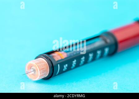 Nahaufnahme der Insulin-Stift-Nadel auf blauem Hintergrund. Stockfoto