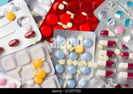 Verschiedene Tabletten, Pillen in Folienblisterpackungen, Medikamente Medikamente auf blauem Hintergrund. Stockfoto