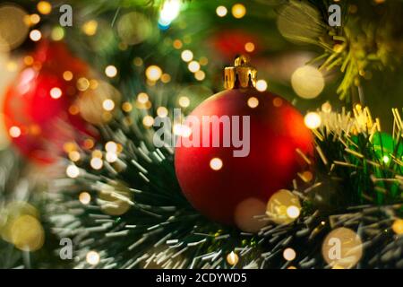 Rote Weihnachtskugel mit verschwommenem Licht. Weihnachtsdekoration. Weihnachtskarte und Neujahrskarte. Rote Weihnachtskugel Nahaufnahme. Stockfoto