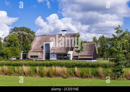 Barneveld, Niederlande- 23. August 2020: Neu gebaute luxuriöse weiße Villa mit Reetdach in Barneveld Holland Stockfoto
