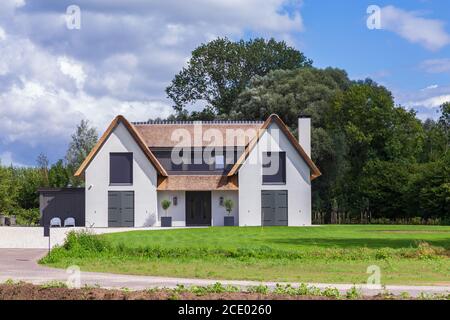 Barneveld, Niederlande- 23. August 2020: Neu gebaute luxuriöse weiße Villa mit Reetdach in Barneveld Holland Stockfoto