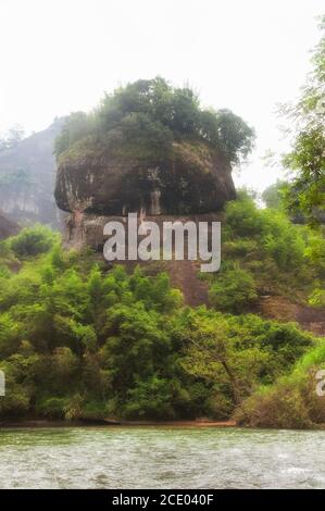 Ungewöhnliche Felsformationen und Bambusbäume säumen die Ufer des neun-Bogen-Flusses in wuyishan an einem bewölkten Tag in der Provinz fujian china. Stockfoto