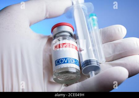Nahaufnahme von Coronavirus-Impfstofffläschchen, Spritze und Nadel in der Hand Stockfoto