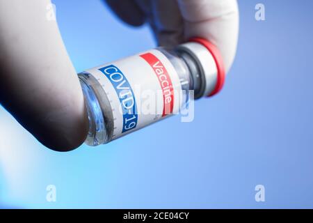 Arzt in sterilen weißen Handschuhen mit Impffläschchen Stockfoto