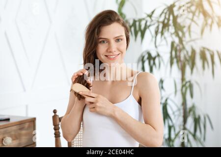 Ziemlich blonde Mädchen Bürsten Haare zu Hause Stockfoto