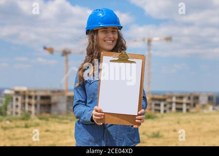 Portrait der jungen Frau Ingenieur hält Zwischenablage mit Dokumenten Stockfoto