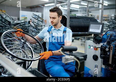 Mechaniker arbeitet mit Fahrrad Rad auf Fabrik Stockfoto