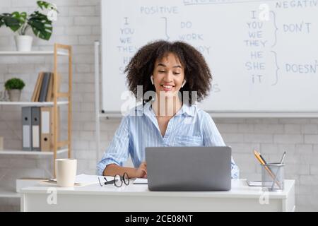 Lehrer arbeitet online während der Quarantäne. Frau chattet mit Studenten im Online-Unterricht im Wohnzimmer Stockfoto