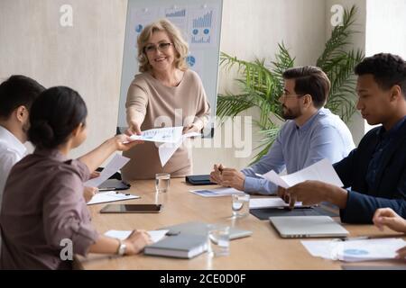 Lächelnde Geschäftsfrau teilt Projektergebnisse mit Investoren. Stockfoto