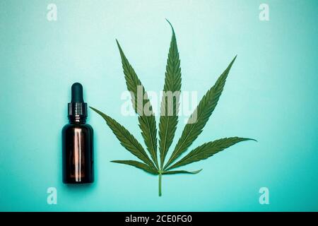 Cannabisöl (Cannabidiol). Medizinisches Cannabis (Marihuana) und Extrakt auf blauem Hintergrund. Stockfoto