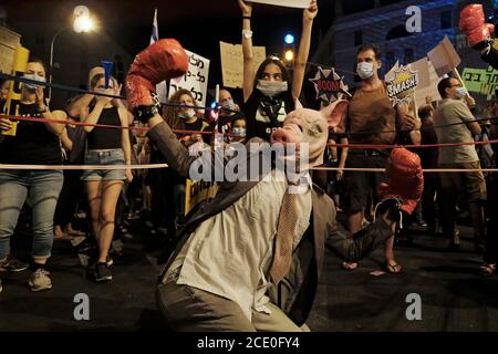 JERUSALEM, ISRAEL - 29. AUGUST: Israelische Demonstranten, Einer trägt eine Schweinemaske und der andere als Schimpansen-Maske führt einen Boxkampf während einer Massendemonstration durch, an der über 25000 Personen im Rahmen der laufenden Demonstrationen gegen Premierminister Benjamin Netanjahu wegen seiner Anklage wegen Korruptionsvorwürfen und des Umgangs mit der Coronavirus-Pandemie in der Nähe des Premierministers teilnahmen Offizielle Residenz des Ministers am 29. August 2020 in Jerusalem, Israel. Eine Welle von Anti-Netanjahu-Protesten hat Israel über den Sommer hinweggefegt, wobei die größte wöchentliche Demonstration jeden Samstagabend in Jerusalem stattfindet. Stockfoto
