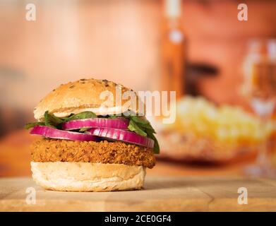 Ein würziger Bohnenburger auf einem geröteten Brötchen mit Rot Zwiebel und Spinat im Restaurant Stockfoto