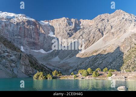 Der Pamir-Bergblick und ruhiger Campingplatz am Kulikalon-See im Fann-Gebirge in Tadschikistan. Bunte Reflexion in pur aufmuntern Stockfoto